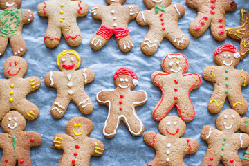 Raw gingerbread men with glaze on a baking sheet