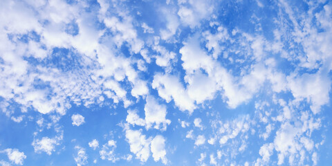 Beautiful fluffy white clouds in blue sky, background. Altocumulus cloud formation