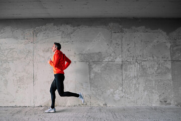 Obraz na płótnie Canvas Full length of middle aged fast runner running in urban exterior.