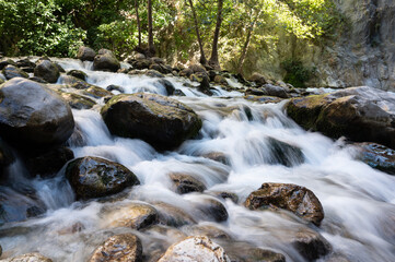 Long exposure shot of mountain water stream flowing among stones