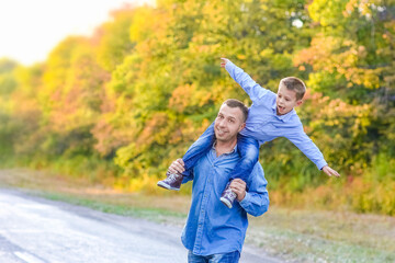 A Happy parent with a child in the park hands on nature travel go along the road