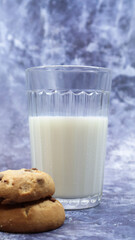 American gluten free chocolate chip cookies with glass glass of vegetable milk on gray background. Chocolate chip cookies. Sweet pastries, dessert. Culinary background. Vertical photography.