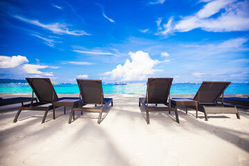 Beach chairs in exotic resort on perfect white sandy beach