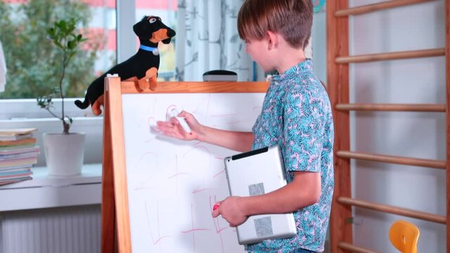 The boy makes a mistake while studying mathematics. He draws an infinity sign on a flipchart. Home education in the room.
