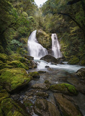 Fototapeta premium Epic waterfall in lush green mossy forest. Stewart Falls New Zealand