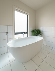 Modern, clean white freestanding bath in bathroom