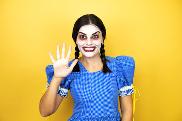 woman wearing a scary doll halloween costume over yellow background showing and pointing up with fingers number five while smiling confident and happy