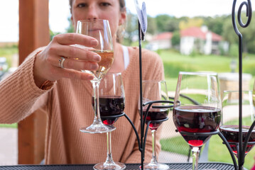 Young woman sampling wine at an outdoor table