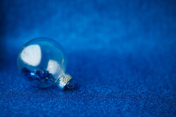 Christmas background with silver and blue ornaments on dark blue.