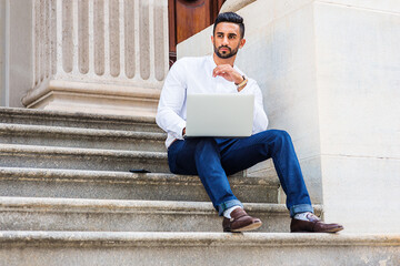 Young East Indian American College Student with beard studying in New York City, wearing white...