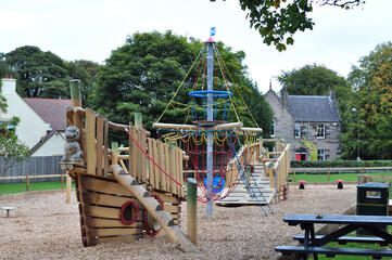 Fototapeta na wymiar View of Deserted Outdoor Children's Play Park with Equipment & Picnic Bench 