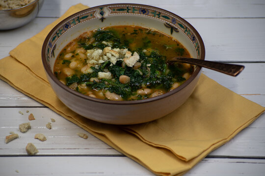 Vegan Bean And Spinach Soup In Bowl On Wooden White Table