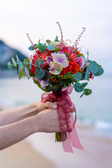 A bouquet of flowers from a wedding ceremony with beautiful colors. The sea on the horizon