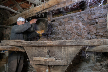 Old mill for grinding grain up close. The miller grinds grain