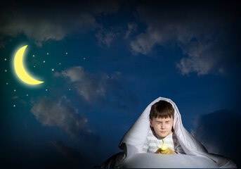 boy under the covers with a flashlight