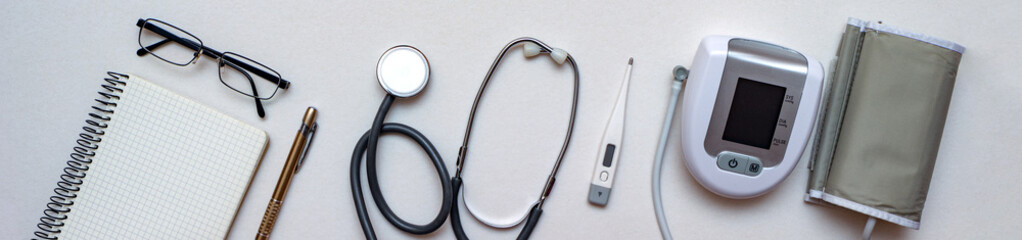 Stethoscope, tonometer, thermometer and doctor's notebook on white background. Concept of first need medical equipment for diagnosis at doctor's office