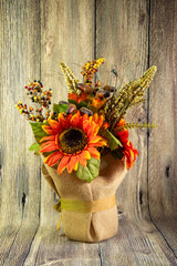 Bouquet of decorative red sunflowers red isolated on wood background. Thanskgiving concept.