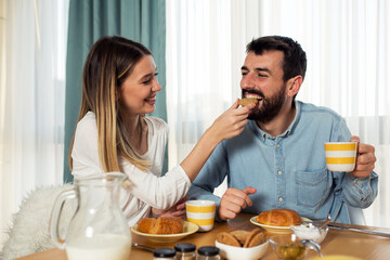 Fototapeta na wymiar Sweet young couple have a breakfast at home