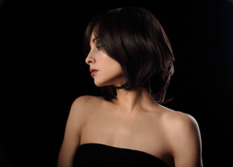 Alluring portrait of short bob hair style woman looking down on black background. Closeup portrait.