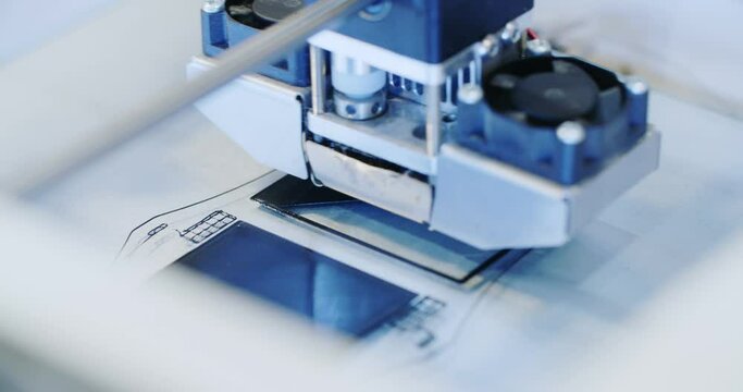 Closeup shot of a 3D printer in the process of printing a black polymer element.
