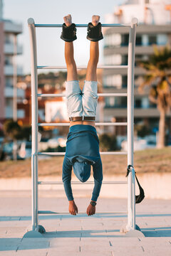 Man Hanging Upside Down On The Horizontal Bar In Anti Gravity Or Inversion Boots. Sports Equipment.Boots Help To Reduce Back Pain, Muscle Tightness And Spasms.To Stretch Neck And Back.Align The Spine 