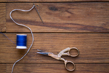 Sewing items on a wooden table. Bird-shaped scissors.