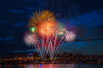 Naklejka premium fireworks over the river in the city