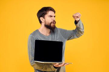 man with laptop wireless technology internet lifestyle work yellow isolated background