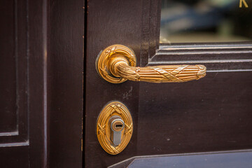 Brass door handle on a colorful blue door