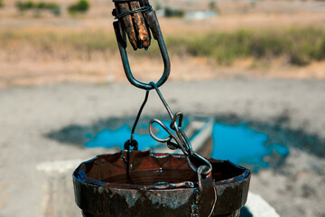 Rusty bucket of old water well © Leilani