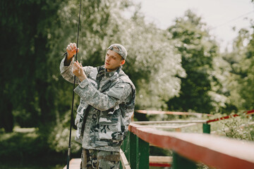 Fototapeta premium A man fishing on a lake. Guy in a uniform.