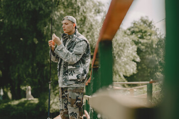 A man fishing on a lake. Guy in a uniform.