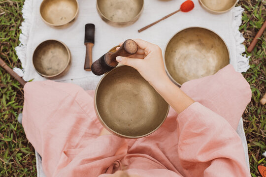 Young woman with white hair in a pink kimono plays on a Tibetan Copper singing bowl. Sound healing, meditation. Rice terraces Jatiluwih High quality 4k footage