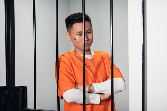 Asian mafia gang member is serving time behind bars. Sad portrait in a prison cell
