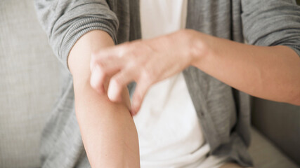 腕をかく若い男性	