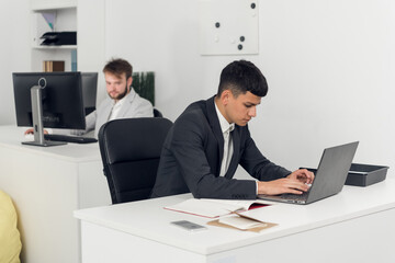 The Manager is busy with office work at a Desk in the open-space office of a large company