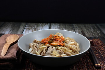 Grilled cutting pork belly with sliced onion seasoning with teriyaki sauce and topping with kimchi (Spicy pickled vegetable in Korea style). Famous special street food menu in Asia. 