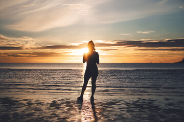 Rear view of young adult travel asian woman relax in nature on beach sea with morning sky