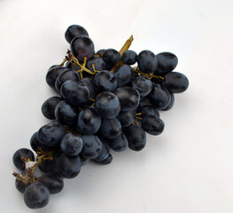 
fresh black grapes lies on a white background
