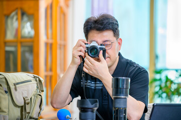 A middle-aged Asian man whose hobby is 35mm/135mm film SLR camera.