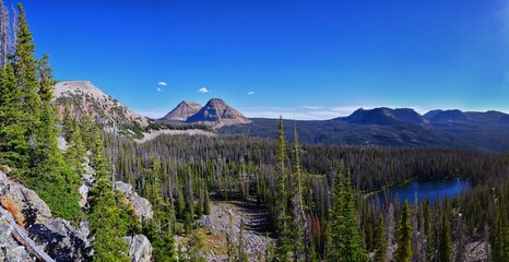 Lake Cuberant hiking trail views of ponds, forest and meadows with Bald Mountain Mount Marsell in Uinta Mountains from Pass Lake Trailhead, Utah, United States.