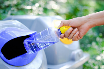 Please dispose of plastic bottle into the tank. A man throw rubbish in the trash can by separate garbage to dispose like hazardous waste ,