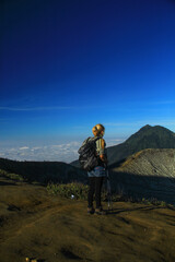 A woman standing at the top of Mount Ijen Banyuwangi Indonesia. Mount Ijen is the most popular tourist destination in Banyuwangi East Java Indonesia