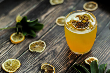 The signature yellow drink decorated with a dehydrated lemon wheel with wood background  