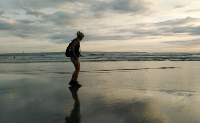 A woman taking picture from the beauty of Petitenget beach Bali Indonesia.