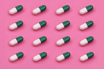 White green capsule Pharmaceutical medicine tablet on a pink background,Medicine creative concepts. Minimal style with colorful paper backdrop.Trendy colors,Trendy pattern