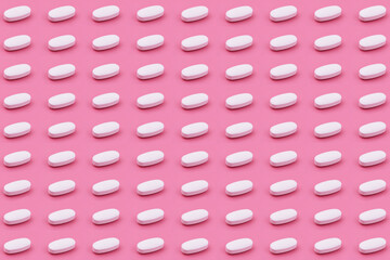 White Pharmaceutical medicine tablet on a pink background,Medicine creative concepts. Minimal style with colorful paper backdrop.Trendy colors,Trendy pattern