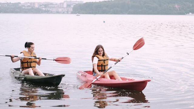 Kayaking and canoeing with friends. Girlfriends on canoe. Friends on kayak ride.