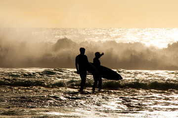 Silhouette of Surfers in Ocean - obrazy, fototapety, plakaty