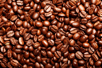 Freshly roasted coffee beans background. Texture of coffee beans. Energy stimulant and smooth java concept with full frame photograph of piled roasting coffee beans backgrounds.